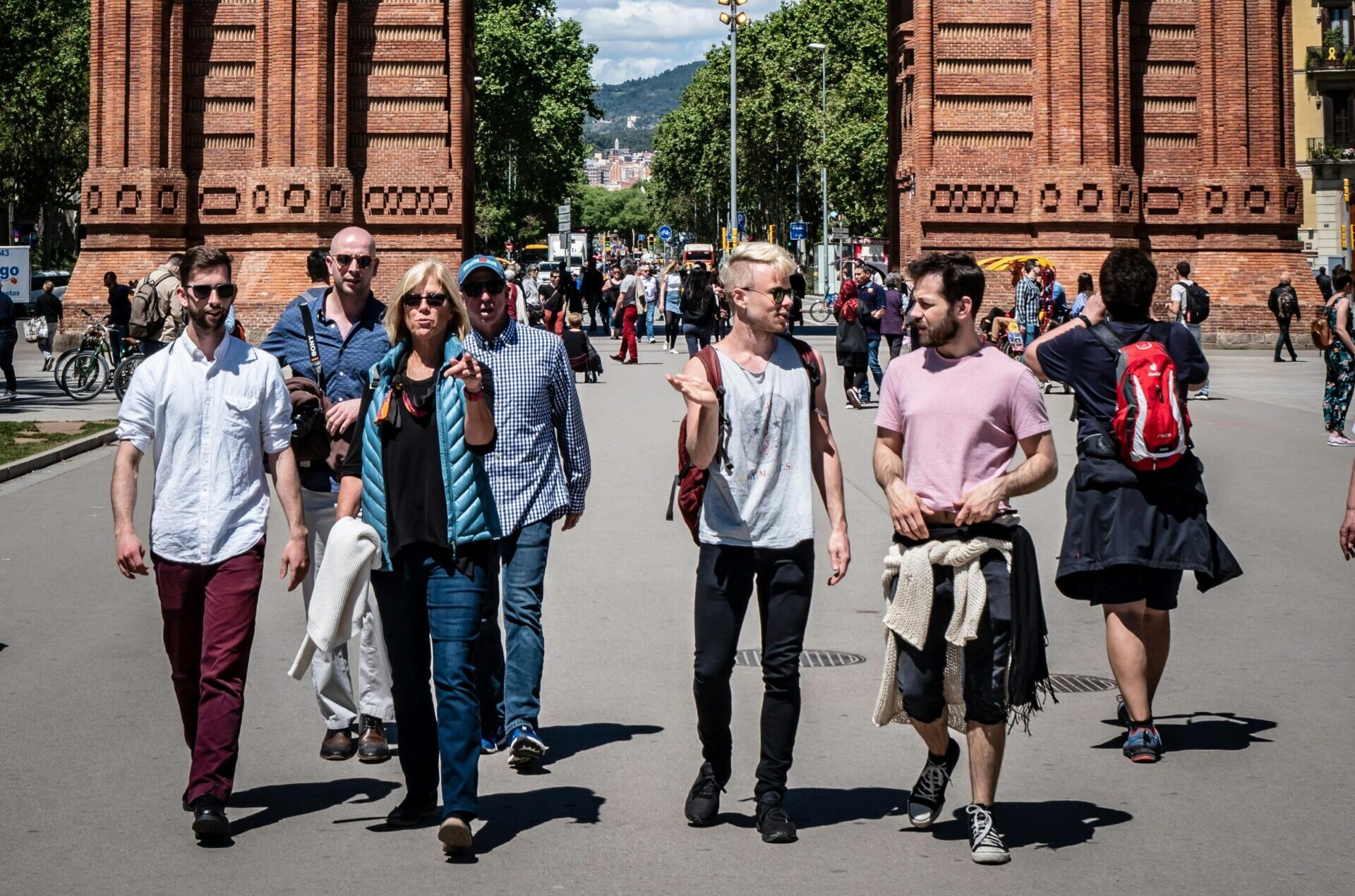 People enjoying a sunny day at the iconic Arc de Triomf in Barcelona, a famous historical landmark.